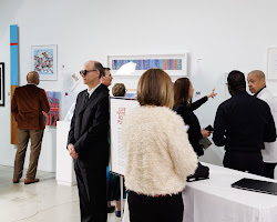 group of people looking at art at an auction